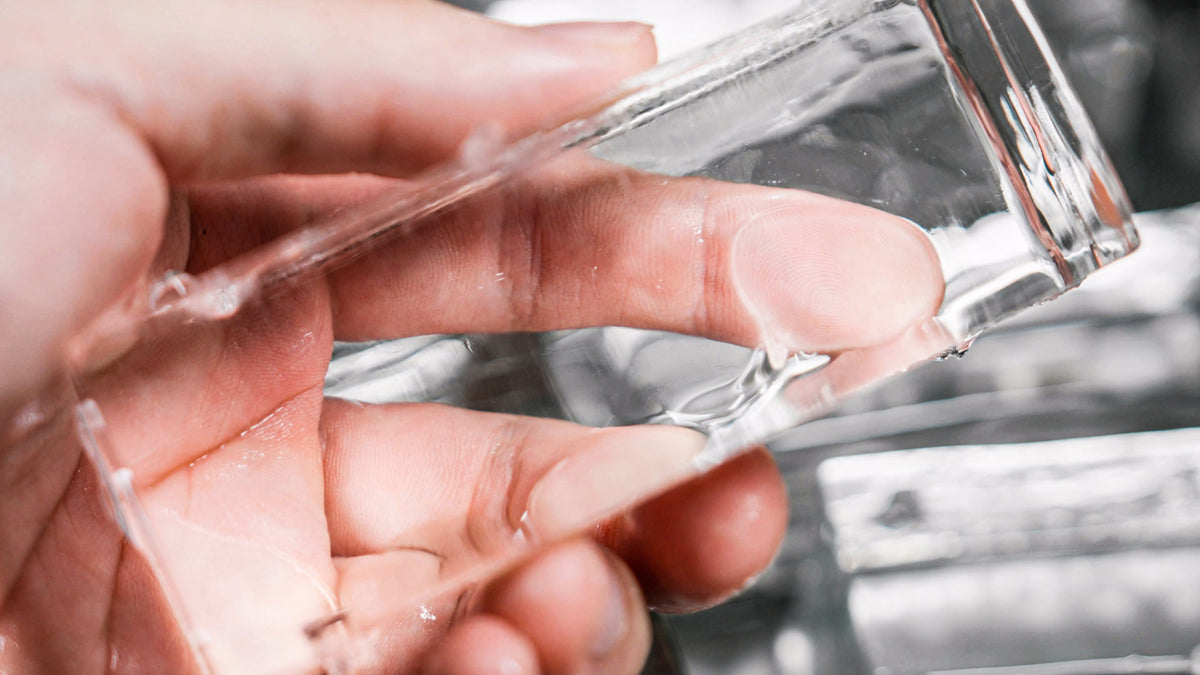 A hand holding a large clear ice bar